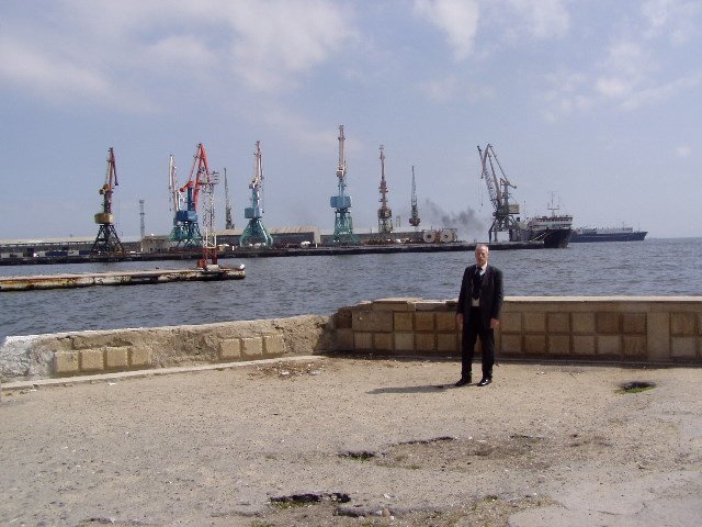 
 Reinhard Brandt an der Hafenmole in Baku am kaspischen Meer. Im Hintergrund die Kräne und Hafenanlagen der Hauptstadt von Aserbaidschan